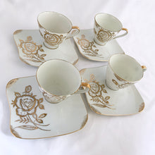 Load image into Gallery viewer, This vintage white porcelain teacup and saucer is absolutely stunning! The unique polygon shaped saucer and teacup are decorated with hand painted gold gilt roses and details. Produced in Japan. In good vintage condition, free from chips, cracks and repairs. Marked "Oakwood Hand Painted Japan". Teacup measures 3 3/14 x 2 3/4 inches | Saucer measures 5 3/4 x 5 x 5 3/4 inches