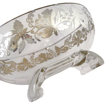 Load image into Gallery viewer, This exquisite vintage flowerlite features a clear oblong shape adorned with a delicate silver overlay of orchid flowers. Crafted by Viking Art Glass in the 1950s, it includes a glass flower frog designed to hold two taper candles and rests on elegant Chinoiserie-style scrolled feet. Ideal for creating sophisticated floral arrangements, this Hollywood Regency piece enhances any space with timeless charm, whether illuminated by candlelight or displayed on its own in both modern and vintage interiors.