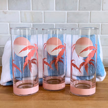 Load image into Gallery viewer, The tropical graphics are the standout feature of these vintage mid-century Panache highball glass tumblers decorated with pink palm trees against a beautiful sunset. Designed by Wolly Clark, circa 1950s. These glasses will definitely add some sweet beachy vibes to your cocktails!  These glasses are in like-new condition, free from chips/cracks/dishwasher damage.  Measures 2 1/2 x 6 1/2 inches  Capacity 13 1/2 ounces