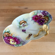 Load image into Gallery viewer, Antique Limoges scalloped oval shaped porcelain vanity tray, hand painted with colourful pansy flowers on a yellow/cream ground with an ornate gold gilt figural flower handle and rim. Crafted by WG & Co., France, 1891 - 1900. A stunning piece of porcelain from William Guerin and Company. In excellent condition, no chips/cracks/repairs. Minor wear to the gold. Measures 10 3/4 x 7 x 3 inches