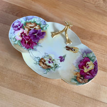 Load image into Gallery viewer, Antique Limoges scalloped oval shaped porcelain vanity tray, hand painted with colourful pansy flowers on a yellow/cream ground with an ornate gold gilt figural flower handle and rim. Crafted by WG & Co., France, 1891 - 1900. A stunning piece of porcelain from William Guerin and Company. In excellent condition, no chips/cracks/repairs. Minor wear to the gold. Measures 10 3/4 x 7 x 3 inches