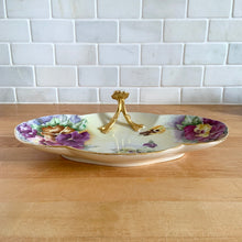 Load image into Gallery viewer, Antique Limoges scalloped oval shaped porcelain vanity tray, hand painted with colourful pansy flowers on a yellow/cream ground with an ornate gold gilt figural flower handle and rim. Crafted by WG & Co., France, 1891 - 1900. A stunning piece of porcelain from William Guerin and Company. In excellent condition, no chips/cracks/repairs. Minor wear to the gold. Measures 10 3/4 x 7 x 3 inches