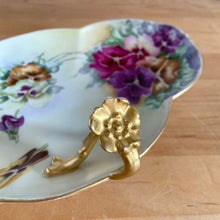 Load image into Gallery viewer, Antique Limoges scalloped oval shaped porcelain vanity tray, hand painted with colourful pansy flowers on a yellow/cream ground with an ornate gold gilt figural flower handle and rim. Crafted by WG & Co., France, 1891 - 1900. A stunning piece of porcelain from William Guerin and Company. In excellent condition, no chips/cracks/repairs. Minor wear to the gold. Measures 10 3/4 x 7 x 3 inches