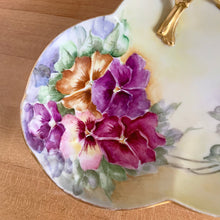 Load image into Gallery viewer, Antique Limoges scalloped oval shaped porcelain vanity tray, hand painted with colourful pansy flowers on a yellow/cream ground with an ornate gold gilt figural flower handle and rim. Crafted by WG & Co., France, 1891 - 1900. A stunning piece of porcelain from William Guerin and Company. In excellent condition, no chips/cracks/repairs. Minor wear to the gold. Measures 10 3/4 x 7 x 3 inches