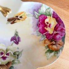 Load image into Gallery viewer, Antique Limoges scalloped oval shaped porcelain vanity tray, hand painted with colourful pansy flowers on a yellow/cream ground with an ornate gold gilt figural flower handle and rim. Crafted by WG & Co., France, 1891 - 1900. A stunning piece of porcelain from William Guerin and Company. In excellent condition, no chips/cracks/repairs. Minor wear to the gold. Measures 10 3/4 x 7 x 3 inches
