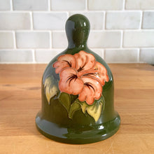 Load image into Gallery viewer, Rare limited edition vintage hand painted art pottery bell featuring tubelined peach hibiscus flowers on an avocado green ground. Designed by Walter Moorcroft. Crafted by Moorcroft Pottery, England, 1983. A beautiful piece for your art pottery collection or to give as a gift! In excellent condition, no chips/cracks/repairs. Signed by Walter Moorcroft in green with the number 30 (30/1000) and the circular Moorcroft Made in England and dated on the exterior of the bell. Measures 3 5/8 x 4 inches
