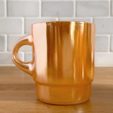 Load image into Gallery viewer, Vintage Fire-King peach lustre milk glass C-handled stackable mug. Crafted by Anchor Hocking, USA, 1950s. These highly collectible mugs are hard to find! In excellent vintage condition, no chips, minor wear. Measures 3 x 3 3/8 inches Capacity 8 ounces