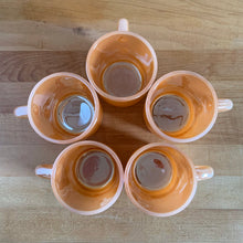 Load image into Gallery viewer, Vintage Fire-King peach lustre milk glass C-handled stackable mug. Crafted by Anchor Hocking, USA, 1950s. These highly collectible mugs are hard to find! In excellent vintage condition, no chips, minor wear. Measures 3 x 3 3/8 inches Capacity 8 ounces