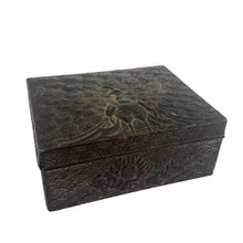 Load image into Gallery viewer, This gorgeous handmade vintage metal lidded trinket box features an embossed proud peacock atop the hinged lid with florals on the side set against a graphic repeating scalloped pattern. The interior is lined with navy blue velvet and the exteriors heavy patina adds to the beauty of the well-crafted box. A stunning piece that will add a bit of mysterious Bohemian whimsy to your decor! In good vintage condition. South East Asian origin. Measures 3 5/8 x 3 x 1 1/2 inches