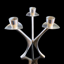 Load image into Gallery viewer, Vintage modernist pewter 3-arm candelabra features a sculptural atomic design that holds three taper candles. Crafted by Brodrene Mylius (BM), Norway, 1960s. An excellent example of mid-century Scandinavian decor.
In excellent condition. Maker's mark, Pewter B M Norway 36500.
Measures 6 x 6 x 6 1/2 inches