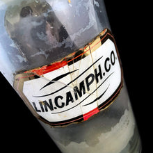 Load image into Gallery viewer, Late 19th century antique hand blown glass pharmacy chemist apothecary jar with stopper. The hand painted label reads LIN.CAMPH.CO. and the label glass has a gold border. Pontil scar on the bottom. These bottles were crafted by skilled glassblowers and used to house chemical compounds in pharmacies...a cool piece of history. In as found condition, there appears to be a crack at the neck and the glass over the label has damage, see photos. Measures 3 3/8 x 9 5/8 inches