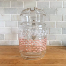 Load image into Gallery viewer, Fantastic vintage mid-century beverage pitcher decorated with a pink basketweave pattern topped with a band of white ivy and ribbed handle. Produced by Federal Glass, circa 1950s. The perfect addition to any style vintage kitchen and your tablescape will thank you! Glassware dreams are made of this beauty! In like new condition, free from chips/wear. The paint is vibrant and shiny. Unmarked. Measures 5 x 8 inches Capacity 90 ounces