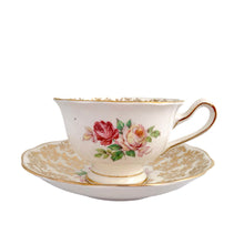 Load image into Gallery viewer, Traditional vintage mid-century era Avon shaped teacup and saucer featuring hand painted pink cabbage roses and heavy gold filigree pattern of flowers on the cup and saucer interiors with gently scalloped gold gilt rims. Crafted by Royal Albert, England, circa 1950s. A beautiful gift or addition to your collection!