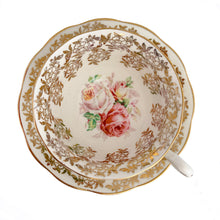 Load image into Gallery viewer, Traditional vintage mid-century era Avon shaped teacup and saucer featuring hand painted pink cabbage roses and heavy gold filigree pattern of flowers on the cup and saucer interiors with gently scalloped gold gilt rims. Crafted by Royal Albert, England, circa 1950s. A beautiful gift or addition to your collection!