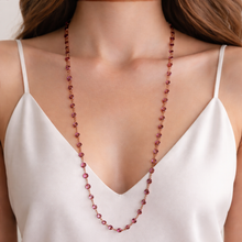 Load image into Gallery viewer, This stunning vintage opera-length necklace, features sparkly dark pink faceted cut crystals set in gold-toned metal, sporting a Swarovski branded tag. Crafted by Swarovski, Austria, 1980s. Wear it long and elegant, doubled for a layered look, or paired with other vintage pieces for effortless glamour. A beautiful example of classic Swarovski craftsmanship, this piece offers luxury sparkle at a fraction of the cost of fine gemstones.