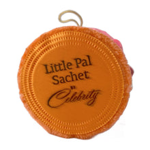 Load image into Gallery viewer, Adorable vintage Little Pal Sachet ceramic fluorescent pink elephant figurine atop a salmon coloured powder puff with string for ease of hanging. Crafted by Celebrity, Japan, 1970s. A sweet bit of retro style to add to your decor! In like new condition in original plastic cylinder package. New old stock. Product is scented. Measures 2 1/2 x 3 3/4 inches