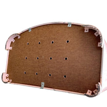 Load image into Gallery viewer, Bottom detail of vintage mid-century modern pink hamper showing ventilation holes in the panel bottom and metal feet.