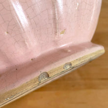 Load image into Gallery viewer, Rare vintage matte pink Sand Butterfly jardiniere planter with embossed vertical bands topped with a border of leaves and butterflies. Crafted by McCoy Pottery, 1930s. This rare planter is must for any McCoy art pottery collector. A wonderful piece to elevate your home and garden decor or to give as a gift!
In as found vintage condition, chips to the rim and crack, no repairs. Normal age-related crazing and manufacturer's glaze pops. Maker's mark on the bottom.
Measures 8 x 7 inches