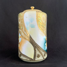 Load image into Gallery viewer, Absolutely exquisite vintage hand painted porcelain lidded ginger jar, crafted by artisans in Japan, late 1800s - early 1900s. It features sweeping panes of pink roses against a yellow and deep teal with alternating peacock feather-like shapes of gold gilt, heavily embellished with moriage, as is the lid. According to Kovels, Nippon Porcelain dates between 1891-1921. After that, US law required imports to be labeled with the country of origin in English. This one-of-a-kind piece.