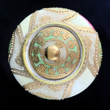 Load image into Gallery viewer, Absolutely exquisite vintage hand painted porcelain lidded ginger jar, crafted by artisans in Japan, late 1800s - early 1900s. It features sweeping panes of pink roses against a yellow and deep teal with alternating peacock feather-like shapes of gold gilt, heavily embellished with moriage, as is the lid. According to Kovels, Nippon Porcelain dates between 1891-1921. After that, US law required imports to be labeled with the country of origin in English. This one-of-a-kind piece.