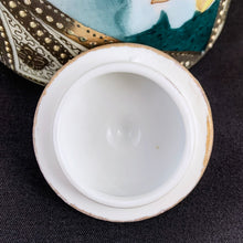 Load image into Gallery viewer, Absolutely exquisite vintage hand painted porcelain lidded ginger jar, crafted by artisans in Japan, late 1800s - early 1900s. It features sweeping panes of pink roses against a yellow and deep teal with alternating peacock feather-like shapes of gold gilt, heavily embellished with moriage, as is the lid. According to Kovels, Nippon Porcelain dates between 1891-1921. After that, US law required imports to be labeled with the country of origin in English. This one-of-a-kind piece.