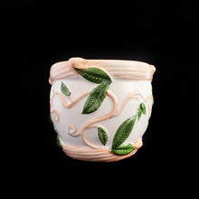 Load image into Gallery viewer, This vintage white ceramic planter is decorated with pink and green raised ivy design. Produced by Claire Burke, Taiwan, circa 1970s. In excellent condition, free from chips/cracks/repairs. Marked "Claire Burke Ti" on the bottom with Made in Taiwan sticker. Measures 7 1/4 x 4 3/8 x 3 1/2 inches