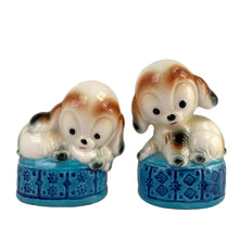 Load image into Gallery viewer, Vintage puppy dogs on blue poofs ceramic salt and pepper shakers with plastic stoppers. Imported by Giftcraft. Japan 1960s. Add these adorable and highly collectible shakers to your collection!
In excellent vintage condition, no chips/cracks/repairs. Giftcraft sticker on one shaker, otherwise unmarked.
Measures 2 x 1 3/4 x 3 1/4 inches