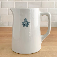 Load image into Gallery viewer, Vintage vitrified stoneware pottery handled pitcher, embossed with the RCAF King’s Tudor logo. Crafted by Medalta Pottery, Canada, 1950s. A nice piece of utilitarian pottery made for the Royal Canadian Air Force.
In excellent condition, no chips/cracks.
Measures 3 7/8 x 5 1/4 inches
