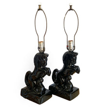 Load image into Gallery viewer, Fabulous pair of vintage rearing black horse ceramic table lamps with brass harps and clear glass marble finials. 1960 or 1970s era judging by the cords and straight pronged plug. These lamps bring all the retro vibes to your home decor!
Both lamps are in excellent condition, no chips/cracks/repairs. New felt on the bottom of each lamp.
Measurements: 7 1/2 x 5 x 12 inches (23 1/2 inches to top of finial)
Suitable for a 9 or 10 inch shade