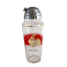 Load image into Gallery viewer, Fabulous vintage art deco rooster-themed cocktail shaker featuring a wide red enamel band bordered on either side with a scalloped band and a large gold rooster. The tapered glass cocktail shaker is finished with a round shoulder and topped off with a silver plate dome lid, crafted by the Derby-Shelton Silver Company, 1930s. This shaker is truly something to crow about!
In used vintage condition, no chips, wear to the gold in the shoulder band.
Measures 4 1/2 x 10 7/8 inches
