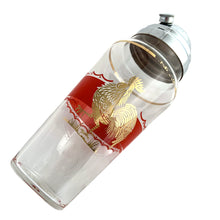 Load image into Gallery viewer, Fabulous vintage art deco rooster-themed cocktail shaker featuring a wide red enamel band bordered on either side with a scalloped band and a large gold rooster. The tapered glass cocktail shaker is finished with a round shoulder and topped off with a silver plate dome lid, crafted by the Derby-Shelton Silver Company, 1930s. This shaker is truly something to crow about!
In used vintage condition, no chips, wear to the gold in the shoulder band.
Measures 4 1/2 x 10 7/8 inches