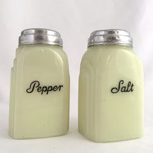 Load image into Gallery viewer, Vintage "Roman Arch" custard uranium glass salt and pepper shaker with the words Salt and Pepper in crisp black script. Produced by McKee Glass, USA, 1930 - 1951. These art deco beauties glow brilliantly under black light and will make a great addition to any vintage kitchen collection!