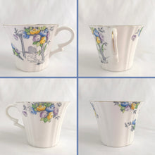 Load image into Gallery viewer, Vintage art deco white bone china teacup and saucer is absolutely gorgeous! Produced by Royal Albert, England, circa 1927 - 1935. Decorated in the "Rosalie" pattern which depicts a hand painted garden path featuring a trellis filled with blue, purple and yellow flowers, trimmed with gold gilt. Excellent condition, free from chips, cracks and repairs. Maker's marks are on the bottom. Teacup measures 3 3/8 x 2 3/4 inches | Saucer measures 5 1/4 inches