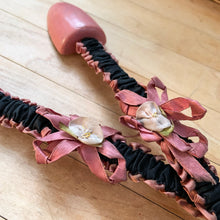Load image into Gallery viewer, Vintage ladies wood and metal shoe stretchers in rose pink with pretty black and rose fabric covers. These feature wood ends between a flexible metal strap. Perfect to help your shoes retain their original shape. Circa 1950s In good vintage condition with minor age-related wear. Measures approximately 11 1/2 inches long