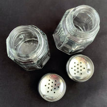 Load image into Gallery viewer, Vintage clear pressed glass paneled salt and pepper shakers with stainless steel lids. Crafted by Dominion Glass, Canada, 1950s. Classic tableware that's always in style!
The glass is in excellent condition, no chips, minor wear to the lids.
Measures 1 3/8 x 3 inches
