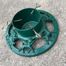Load image into Gallery viewer, Get ready to put up the Christmas tree using this gorgeous cast iron stand in hunter green, decorated with Santa Claus in his sleigh with reindeer! The perfect addition to your vintage or modern Christmas decor.
In used vintage condition.
Dimensions: 14 inch diameter, reservoir measures 6 1/4 x 4 1/4 inches