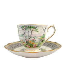Load image into Gallery viewer, Vintage "Silver Birch" porcelain teacup and saucer. Crafted by Royal Albert, England, 1935 - 1945. This beautiful pattern consists of lakeside woodland scene of birch trees and colourful flowers surrounded with a border of rustic gray and cream, rimmed in gold gilt. In excellent condition, free from chips/cracks/repairs.