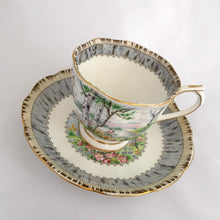 Load image into Gallery viewer, Vintage "Silver Birch" porcelain teacup and saucer. Crafted by Royal Albert, England, 1935 - 1945. This beautiful pattern consists of lakeside woodland scene of birch trees and colourful flowers surrounded with a border of rustic gray and cream, rimmed in gold gilt. In excellent condition, free from chips/cracks/repairs.