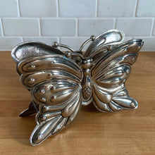Load image into Gallery viewer, Vintage silver plated figural butterfly napkin holder. Crafted by Godinger, 1980s. This beautifully detailed butterfly may be used to hold napkins or as a desk accessory to hold letters. Also makes a lovely home decor accent. In excellent condition with natural patina. Measures 7 x 2 1/2 x 4 3/4 inches