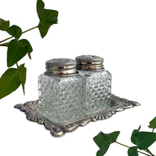 Load image into Gallery viewer, Vintage diamond pattern cut glass salt and pepper shakers with silver plate lids and tray. Crafted in Hong Kong, circa 1960s. A sweet set for your tablescape! In excellent vintage condition. Shakers measure 1 x 1 x 1 3/4 inches. Tray measures 3 1/8 x 2 3/8 inches.