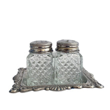 Load image into Gallery viewer, Vintage diamond pattern cut glass salt and pepper shakers with silver plate lids and tray. Crafted in Hong Kong, circa 1960s. A sweet set for your tablescape! In excellent vintage condition. Shakers measure 1 x 1 x 1 3/4 inches. Tray measures 3 1/8 x 2 3/8 inches.