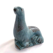 Load image into Gallery viewer, Vintage seal perched on rocks redware figurine, finished in slate blue drip glaze with a matte finish. Crafted by Blue Mountain Pottery, Canada, circa 1970s. A beautiful and highly collectible piece of pottery from this iconic brand! Excellent condition, free from chips/cracks/repairs. Measures 5 3/4 x 4 x 7 1/2 inches