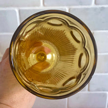 Load image into Gallery viewer, Known as the "crystal of the southwest", this "St. Genevieve" amber pressed glass footed iced tea goblet is striking with its beautifully designed series of arches, dots and cut vertical ribs, ball stem and round star foot. Produced by the Bartlett-Collins Glass Company, USA, between 1950-1970. A great piece to add to your drinkware collection! In excellent condition, free from chips/cracks. Measures approximately 3 1/4 x 6 1/4 inches