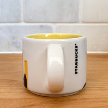 Load image into Gallery viewer, This sweet Starbucks collectible NEW YORK mini ceramic mug Christmas ornament from the You Are Here Collection, 2016. This white mug features a graphic skyline design in shades of yellow, orange and blue with yellow interior. Celebrate the Empire State with an espresso!
In excellent condition, free from chips/cracks/wear.
Measures 2 3/8 x 1 7/8 inches
Capacity 2 ounces