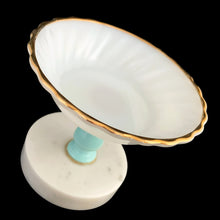 Load image into Gallery viewer, Vintage Italian milk glass compote dish tilted to show interior swirl pattern and full scalloped gold rim detail, with aqua pedestal and marble base visible below