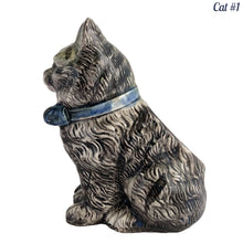 Load image into Gallery viewer, Vintage skillfully hand painted figural tabby cat ceramic planters with intense expressions. These planters have a distinct painting style and date to the 1930s. Features a dark charcoal tabby cat with soulful gray eyes and gray ears, wearing a blue bow tie. In excellent condition, free from chips/cracks/repairs. Impressed mark on the bottom reads, Made in Japan. Measure 6 1/8 x 4 1/2 x 7 inches