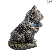 Load image into Gallery viewer, Vintage skillfully hand painted figural tabby cat ceramic planters with intense expressions. These planters have a distinct painting style and date to the 1930s. Features a dark charcoal tabby cat with soulful gray eyes and gray ears, wearing a blue bow tie. In excellent condition, free from chips/cracks/repairs. Impressed mark on the bottom reads, Made in Japan. Measure 6 1/8 x 4 1/2 x 7 inches