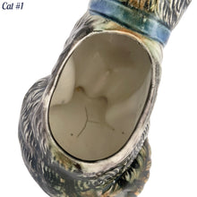 Load image into Gallery viewer, Vintage skillfully hand painted figural tabby cat ceramic planters with intense expressions. These planters have a distinct painting style and date to the 1930s. Features a dark charcoal tabby cat with soulful gray eyes and gray ears, wearing a blue bow tie. In excellent condition, free from chips/cracks/repairs. Impressed mark on the bottom reads, Made in Japan. Measure 6 1/8 x 4 1/2 x 7 inches