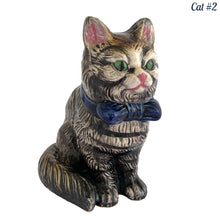 Load image into Gallery viewer, Vintage skillfully hand painted figural tabby cat ceramic planters with intense expressions. These planters have a distinct painting style and date to the 1930s. Features dark charcoal and brown tabby cat with piercing green eyes, pink ears, wearing a blue bow tie. In excellent condition, free from chips/cracks/repairs. Impressed mark on the bottom reads, Made in Japan. Measure 6 1/8 x 4 1/2 x 7 inches