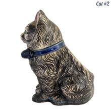 Load image into Gallery viewer, Vintage skillfully hand painted figural tabby cat ceramic planters with intense expressions. These planters have a distinct painting style and date to the 1930s. Features dark charcoal and brown tabby cat with piercing green eyes, pink ears, wearing a blue bow tie. In excellent condition, free from chips/cracks/repairs. Impressed mark on the bottom reads, Made in Japan. Measure 6 1/8 x 4 1/2 x 7 inches